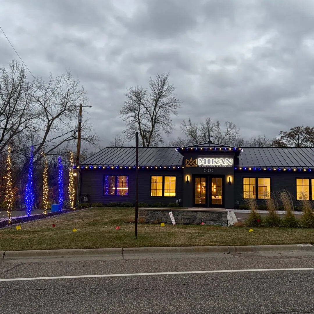 Twin Cities home with warm-white roofline lighting glowing over deep snow